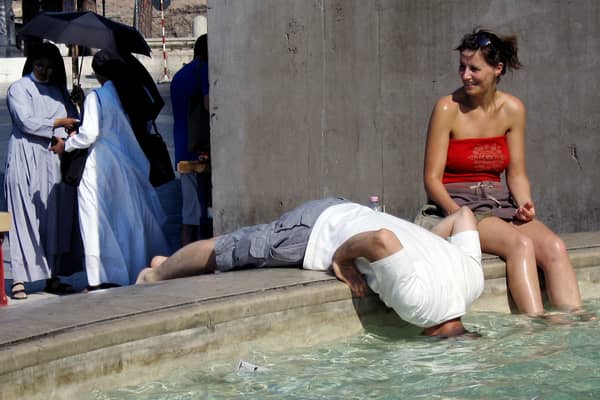 Tourists refresh themselves in the water of a fountain in downtown Rome in 2005 (Photo: VINCENZO PINTO/AFP via Getty Images)