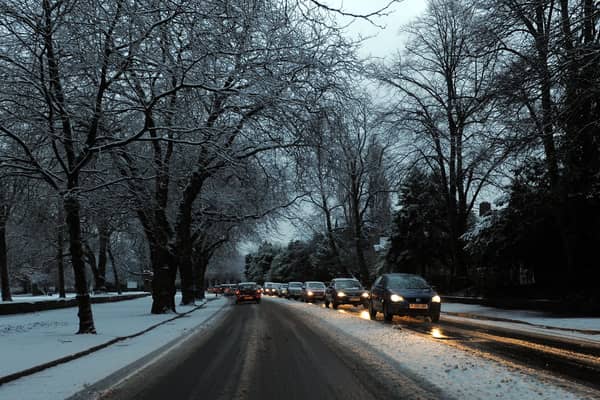Cars drive on snowy roads in Liverpool.