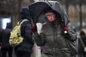Woman walks in stormy conditions.