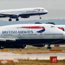 A British Airways plane lands as two other grounded planes sit on the runway at Heathrow Airport.