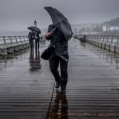 People battle against the wind and rain.