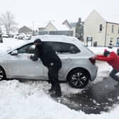 Stock image of car being pushed out of snow.
