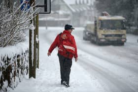 A postman makes his way through the snow.