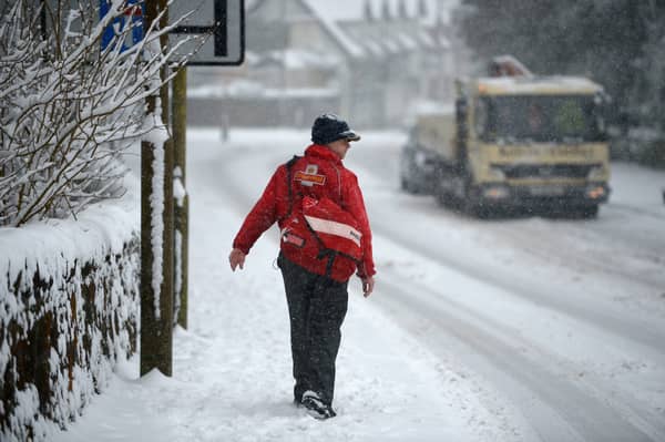 A postman makes his way through the snow.