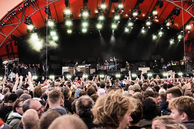 Spectators cheer as they attend a concert of US rock band Foo Fighters performing on the Orange Stage at Roskilde Festival on July 5, 2024 in Roskilde, Denmark.