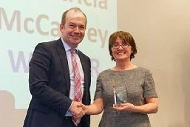 Dr Patricia McCaffrey pictured receiving an award from Sir Michael McBride.