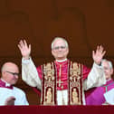 TOPSHOT - Newly elected Pope Leo XIV, Robert Francis Prevost arrives on the main central loggia balcony of the St Peter's Basilica for the first time, after the cardinals ended the conclave, in The Vatican, on May 8, 2025. Robert Francis Prevost was on Thursday elected the first pope from the United States, the Vatican announced. A moderate who was close to Pope Francis and spent years as a missionary in Peru, he becomes the Catholic Church's 267th pontiff, taking the papal name Leo XIV. (Photo by Alberto PIZZOLI / AFP) (Photo by ALBERTO PIZZOLI/AFP via Getty Images)