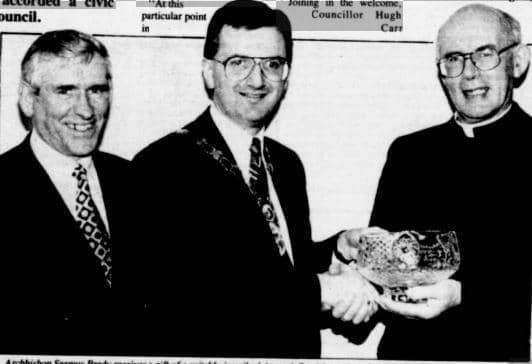 Archbishop Seamus Brady receives a gift of a suitably inscribed Armagh bowl from council chairman, Mr Danny Kennedy. Also pictured is Council Clerk and Chief Executive, Mr Kevin O'Neill.