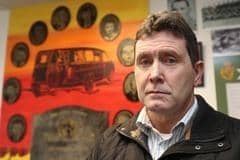 Colin Worton , whose brother Kenneth was killed in the Kingsmills Massacre. In the background is a collage of all ten victims.