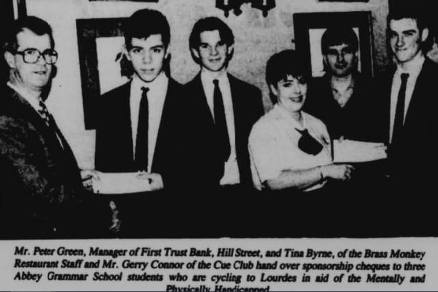 Mr Peter Green, Manager of First Trust Bank, Hill Street, and Tina Byrne, of the Brass Monkey Restaurant staff and Mr Gerry Connor of the Cue Club hand over sponsorship cheques to three Abbey Grammar students who were cycling to Lourdes in 1994.