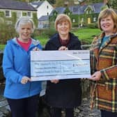 Hiking Hens present a cheque following their walk.