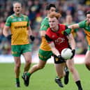 Danny Magill gets a pass away despite a tackle from fullback Brendan McCole when Down played Donegal in the Ulster semi-final. Pics: Brendan Monaghan