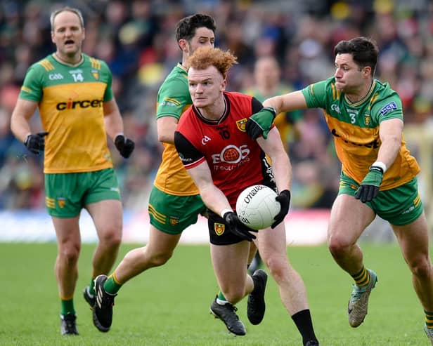 Danny Magill gets a pass away despite a tackle from fullback Brendan McCole when Down played Donegal in the Ulster semi-final. Pics: Brendan Monaghan