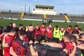 The Down hurling team huddles around their manager, Ronan Sheehan.