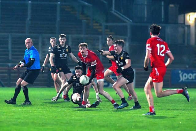 Derry’s Brendan Rogers off loads the ball to Paul Cassidy (12). Photo: George Sweeney