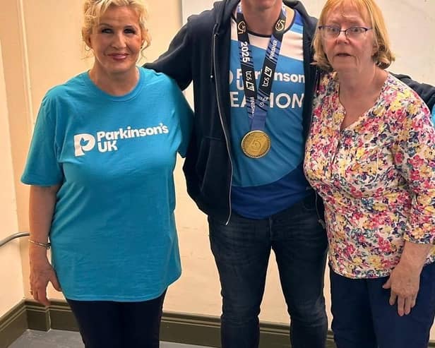 Eamon McConville with his London marathon medal, pictured with Newry Support Group Coordinator Cathy Fegan (left) and his mum Mairin (right).