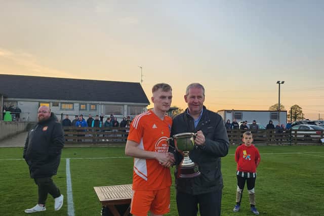 Damolly captain James Magowan is presented with the John Magee Memorial Cup.