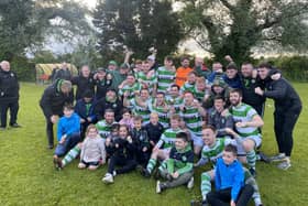 Newry Celtic's players and management celebrate with the AOH Cup.