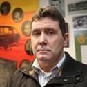 Colin Worton , whose brother Kenneth was killed in the Kingsmills Massacre. In the background is a collage of all ten victims.