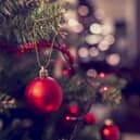 Closeup of red bauble hanging from a decorated Christmas tree. Retro filter effect.; Shutterstock ID 317033810; Purchase Order: -