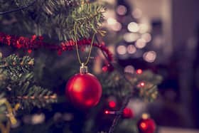 Closeup of red bauble hanging from a decorated Christmas tree. Retro filter effect.; Shutterstock ID 317033810; Purchase Order: -