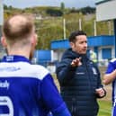 Newry City manager Darren Mullen talks to his players.