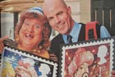 Pantomime dame, May McFettridge launches Royal Mail's Christmas stamps with Newry postman Anthony Morgan.