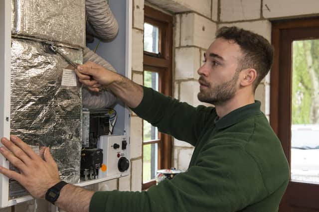 An OFTEC technician checking a boiler