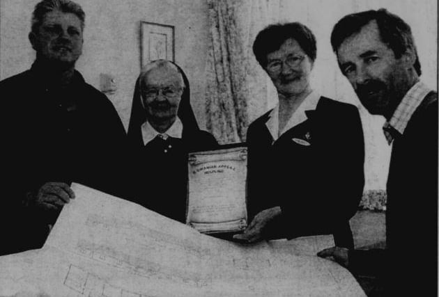 Gerry Morgan (Chairman of Romanian Appeal Helpline) shows the plans for a new orphanage to Sr Ann Murphy and St Tarcisius. Also in the picture is Paul Rogan (Romanian Appeal Helpline Co-Ordinator). The Sisters received a certificate in recognition of their generous donation of equipment including theatre lamp and hospital beds.