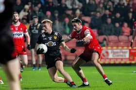 Derry’s Chrissy McKaigue tackles Liam Kerr of Down. Photo: George Sweeney