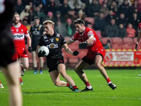 Derry’s Chrissy McKaigue tackles Liam Kerr of Down. Photo: George Sweeney