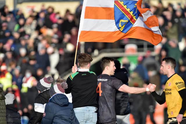The Armagh flag is displayed high and proud, as Armagh's Aidan Forker speaks with Tyrone's Niall Morgan after their 2022 league game.